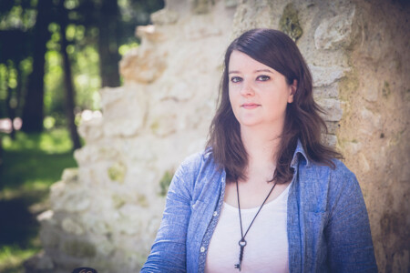 Photo : Élise Schipman Clem devant un mur de pierre
